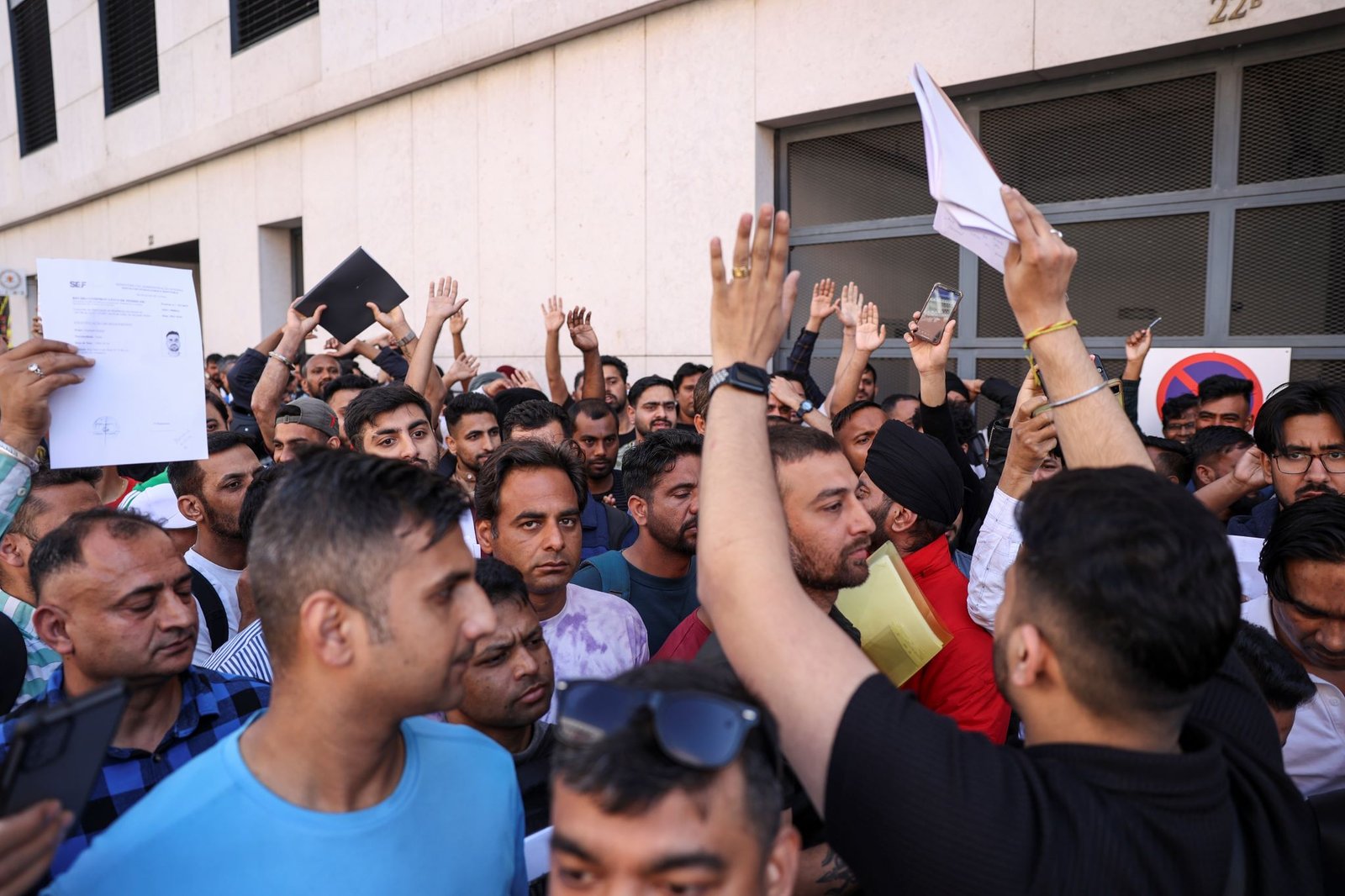 Manifestantes exibem documentos de pedido e renovação de residência em Portugal junto à da sede da Aima. Em 18 de abril de 2024. Crédito: Miguel A. Lopes, Lusa