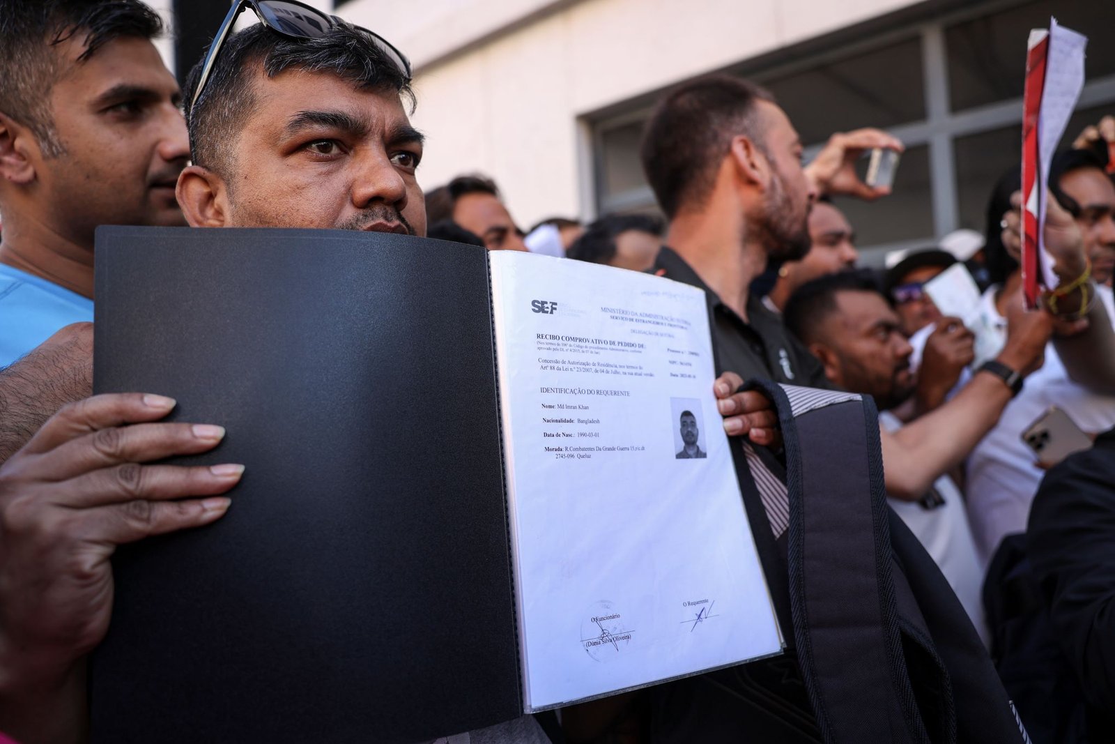 Manifestantes exibem os documentos de pedido e renovação de residência em Portugal. Crédito: Miguel A. Lopes, Lusa